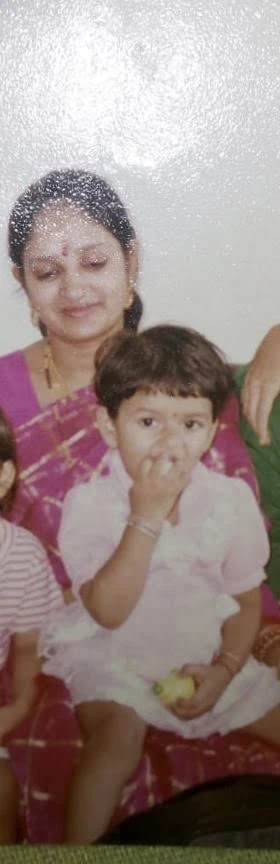 Anuja as a small child, held by her mother